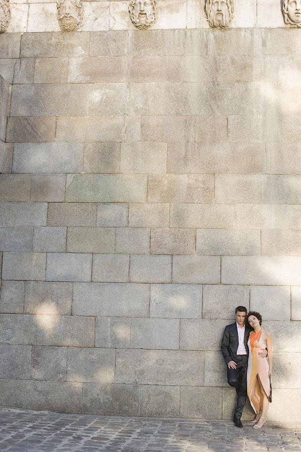 Couple leaning against wall Photograph by Symphonie Ltd