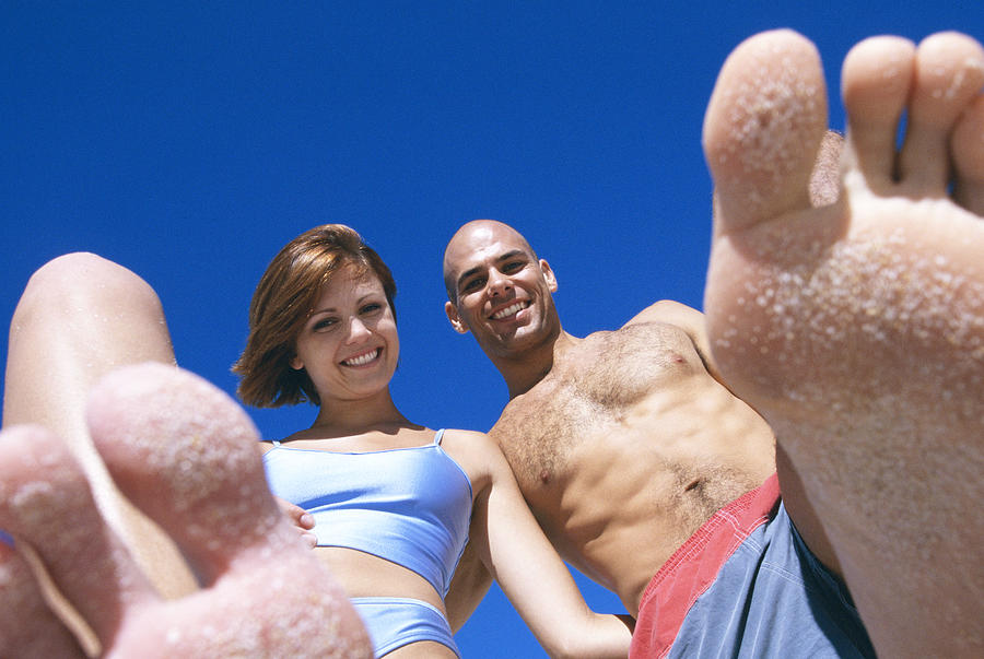 Couple on beach with sand on feet Photograph by Jacobs Stock Photography