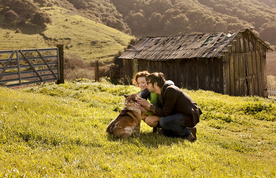 Couple petting dog in rural landscape Photograph by Jim Purdum