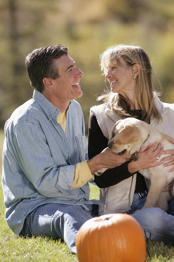 Couple playing with dog Photograph by Comstock Images