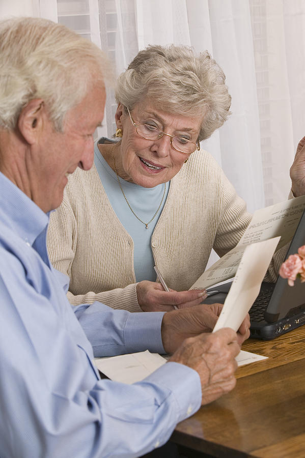 Couple reading paperwork Photograph by Comstock Images