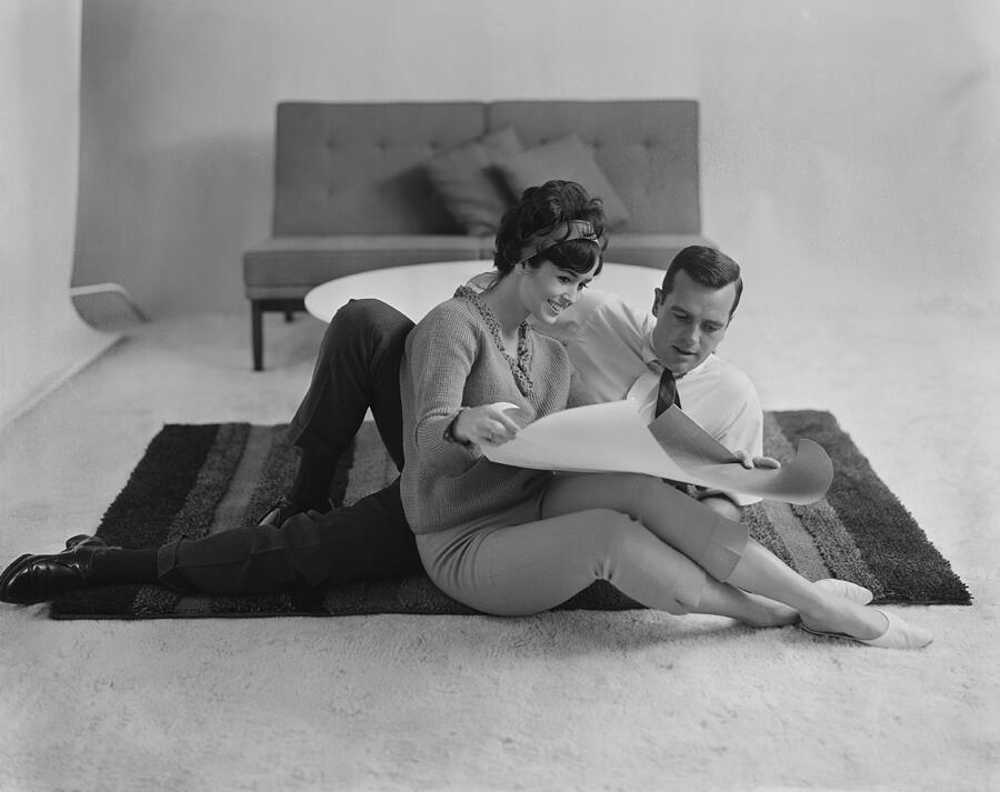 Couple sitting on carpet watching blue print Photograph by Tom Kelley Archive