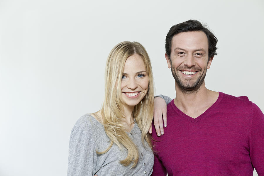 Couple smiling against white background, portrait Photograph by Westend61