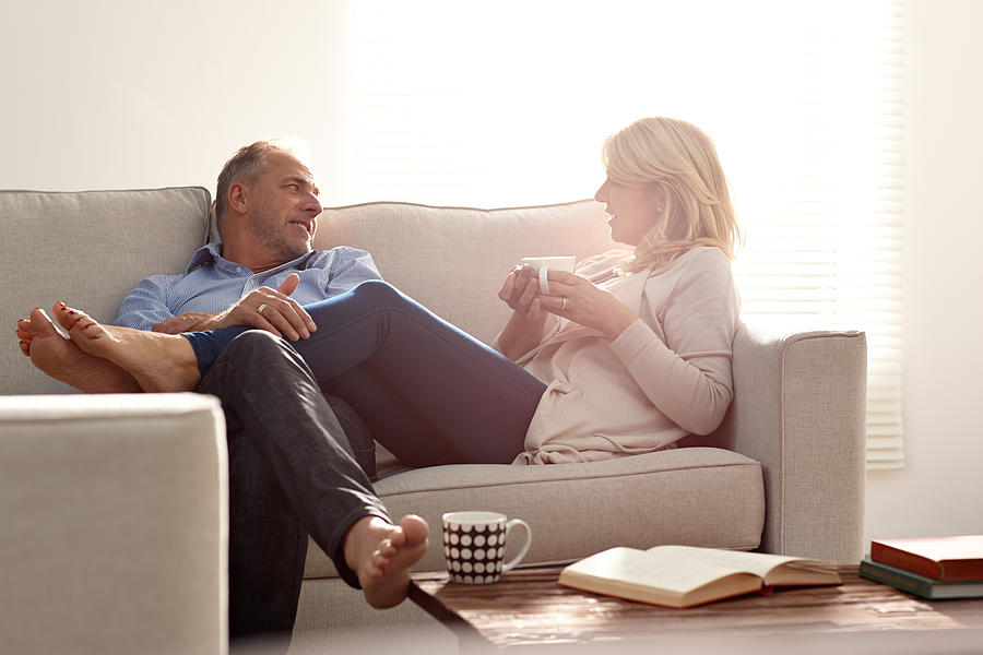 Couple talking in living room with coffee Photograph by Dean Mitchell