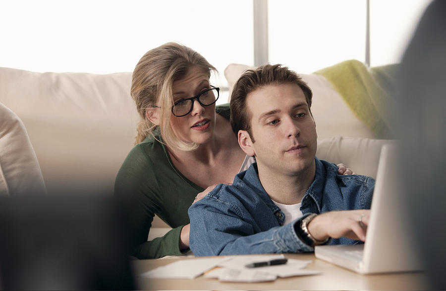 Couple using laptop at home Photograph by Comstock Images