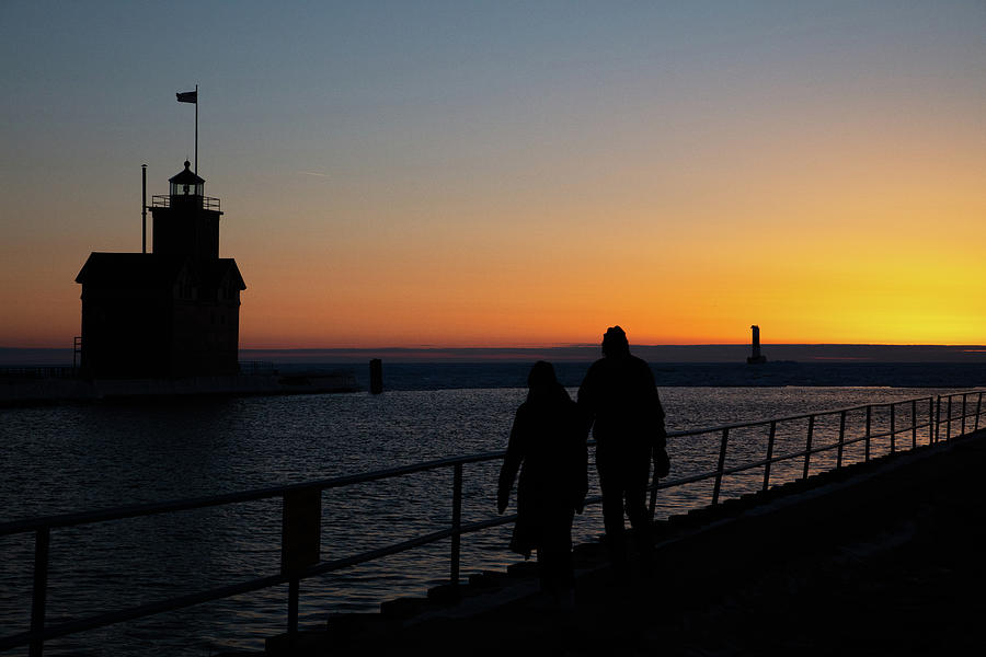 Couple walking at sunset on the Holland Michigan Pier  Photograph by Eldon McGraw