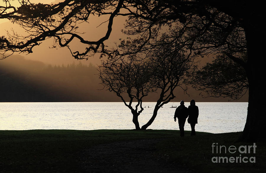 Couple walking by Derwent Water, Keswick Photograph by Bryan Attewell