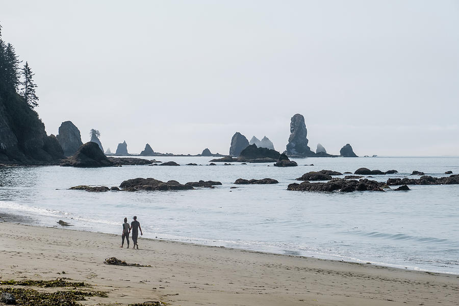 Couple walking on Third beach, WA Photograph by Alberto Zanoni