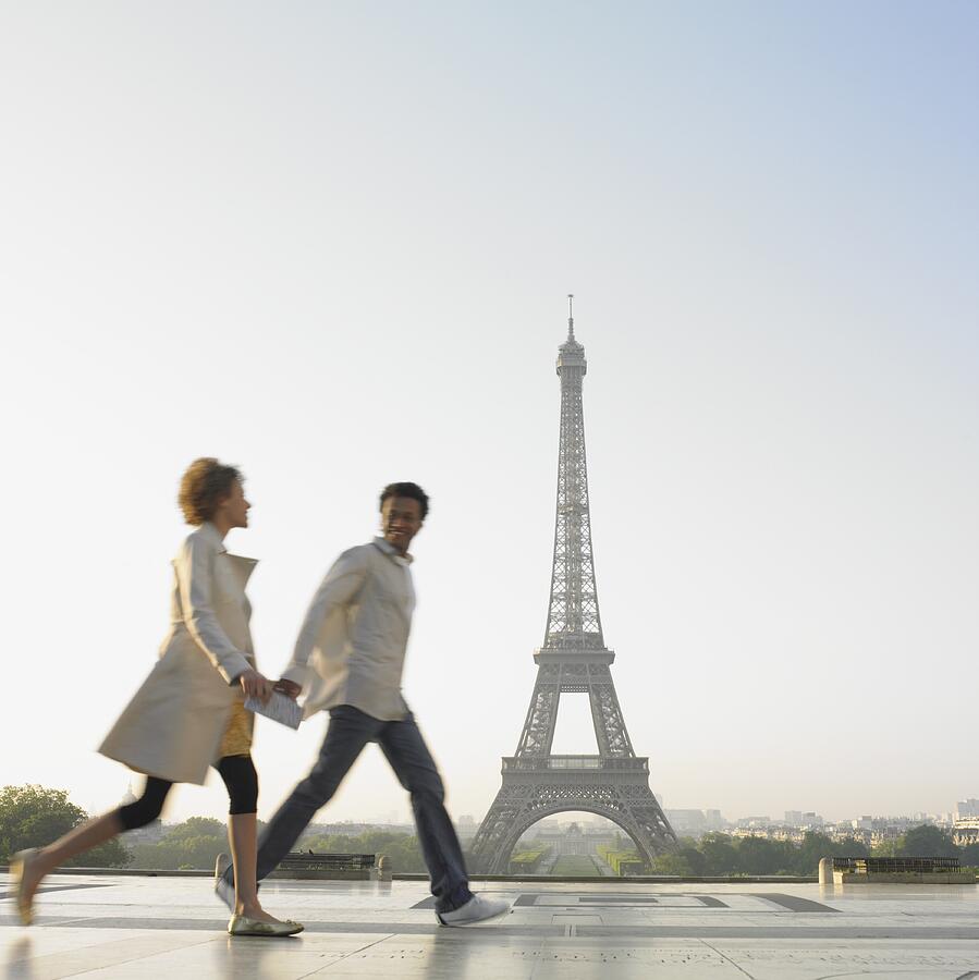 Couple walking with Eiffel Tower in background Photograph by Blend Images - Dave & Les Jacobs