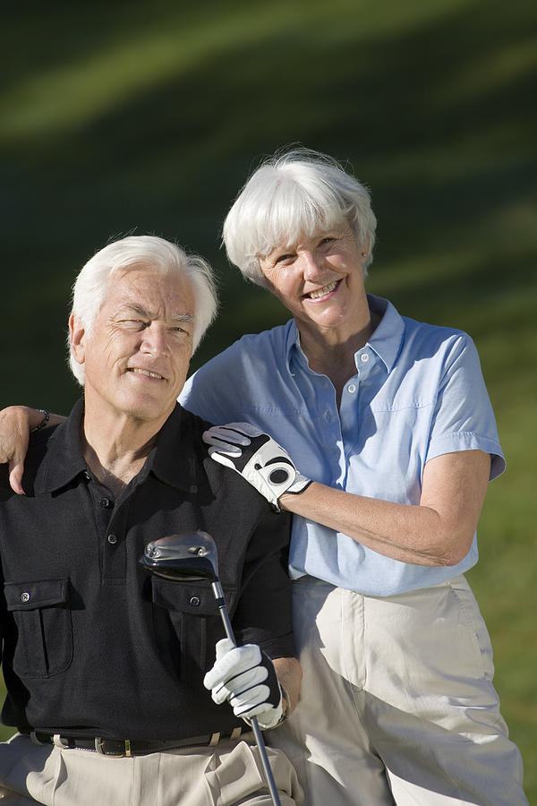 Couple with golf club Photograph by Comstock Images