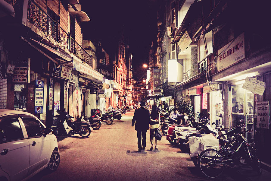 Couples walking on Hanoi street Photograph by Suphat Bhandharangsri Photography