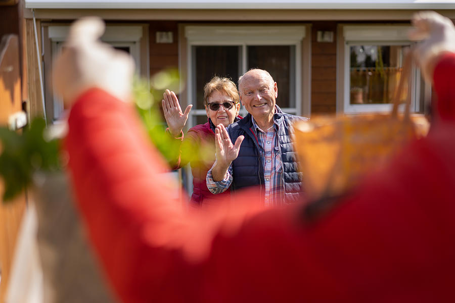 Covid-19 Food Delivery, Happy Senior Couple Waving In Front Of Their House Photograph by Amriphoto