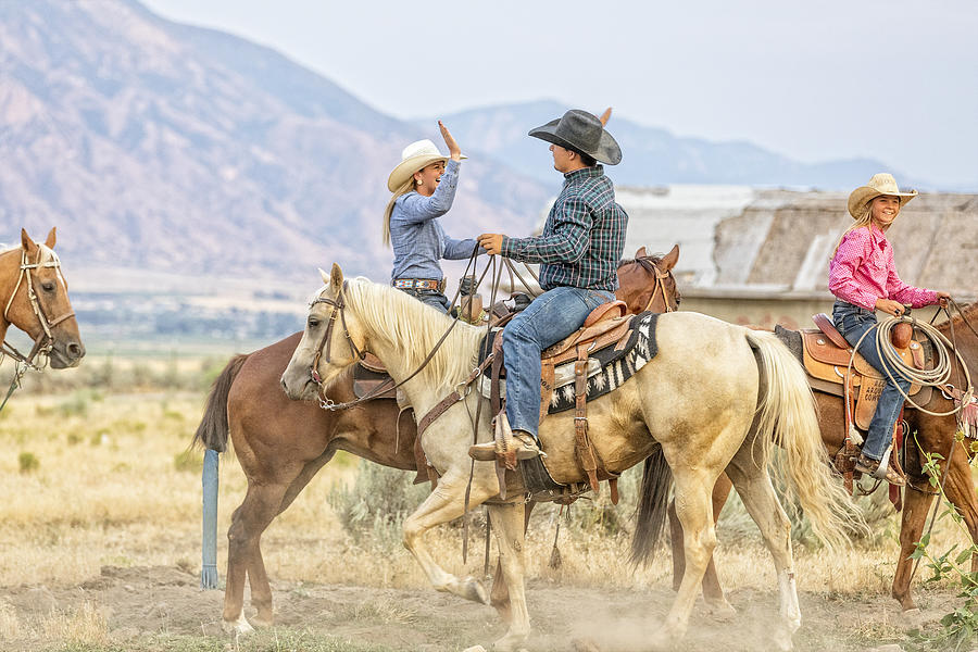 Cowgirl and cowboy congratulate each other while on horseback Photograph by TerryJ