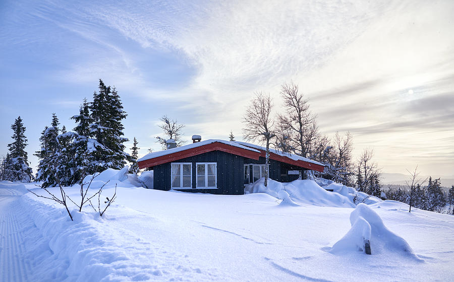 Cozy mountain cabin with deep snow and snowflakes in the air, Oppland County Norway Photograph by Romaoslo