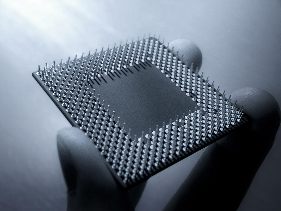 CPU Processor chip held in fingers Photograph by Rafal