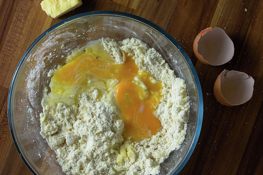 Cracked eggs in a clear bowl of flour and cheese Photograph by Scott Lyons
