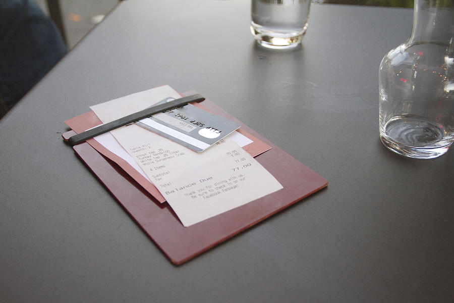 Credit card with bill on restaurant table Photograph by Roy Hsu