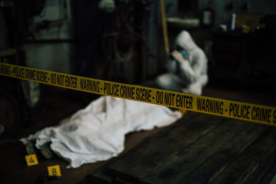 Crime scene investigation - forensic investigating behind dead cover body and evidence Photograph by FlyMint Agency