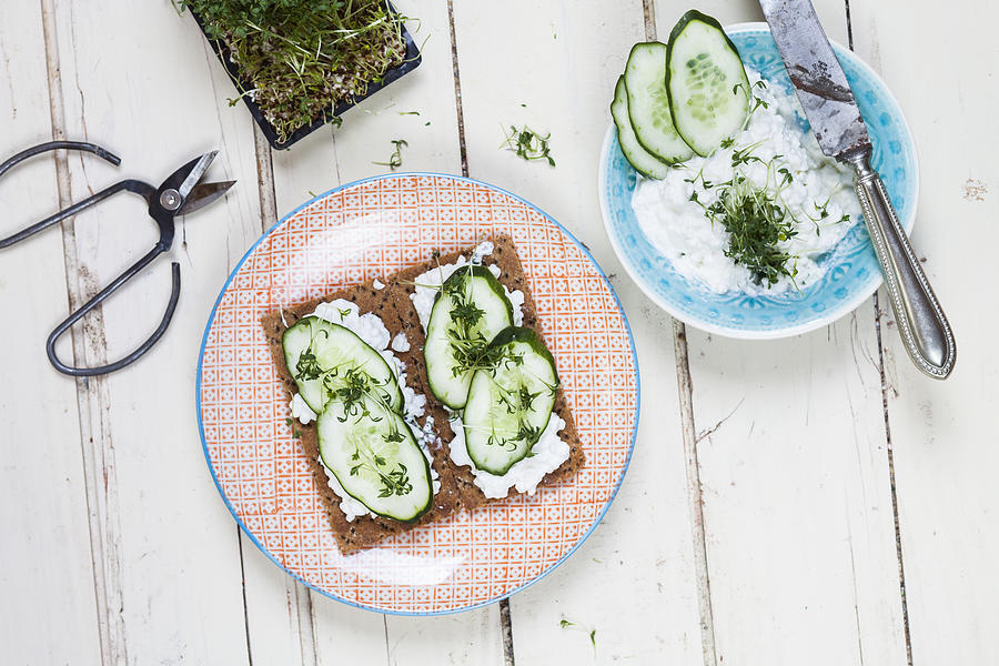 Crispbreads with cottage cheese, cucumber slices and cress Photograph by Westend61