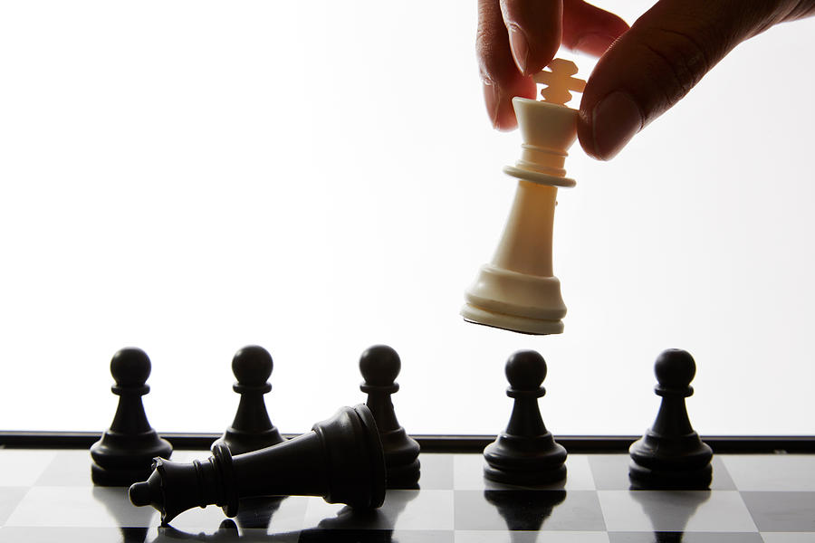Cropped Hand Of Man Playing Chess Against White Background Photograph by Nupat Arjkla / EyeEm
