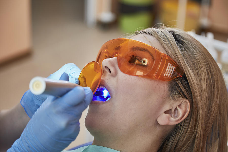 Cropped image of dentist giving filling to female patient Photograph by Alexandr Sherstobitov