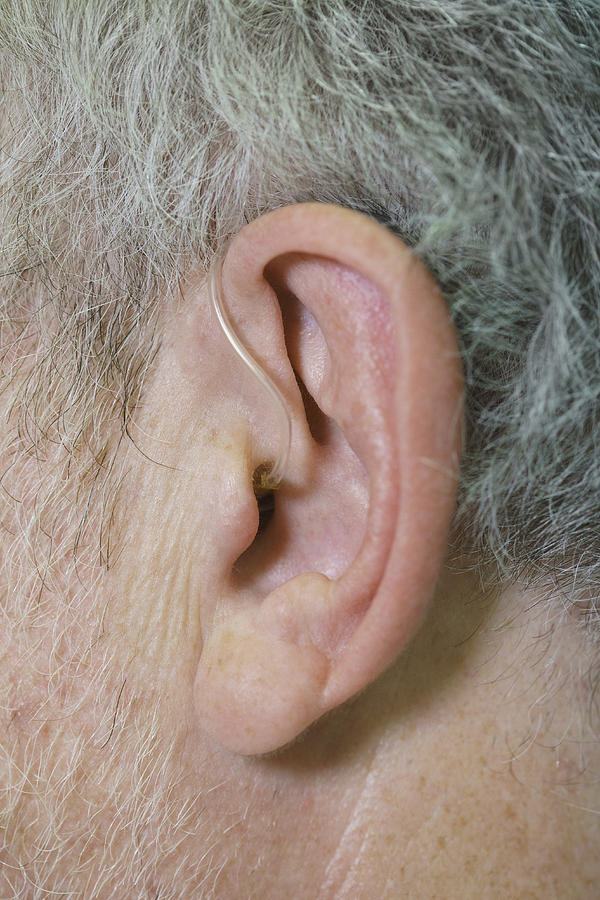 Cropped image of man wearing hearing aid Photograph by Halfdark