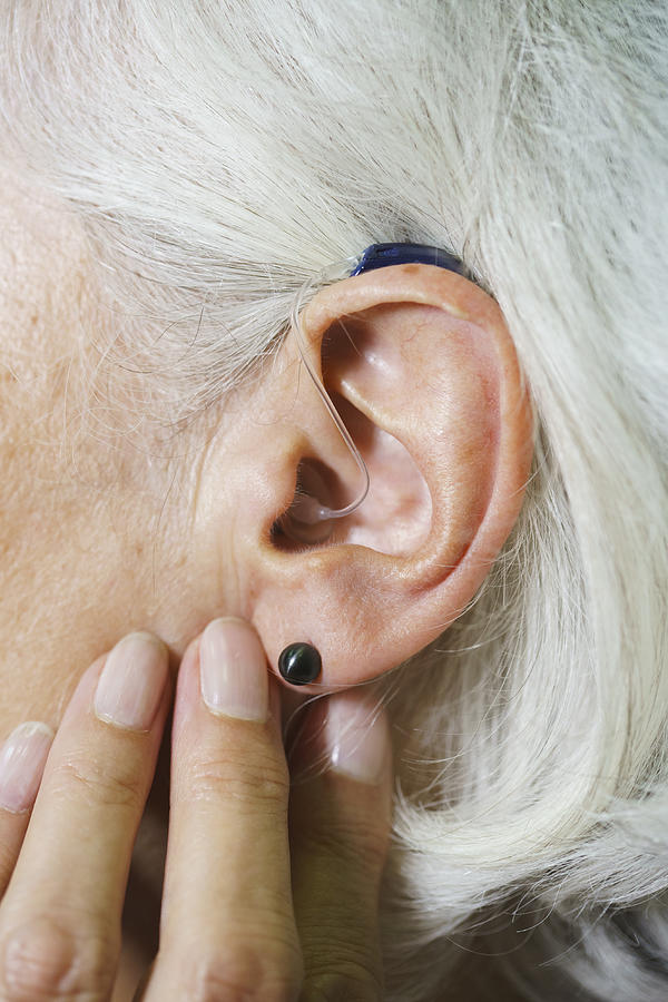 Cropped image of senior woman wearing hearing aid Photograph by Halfdark