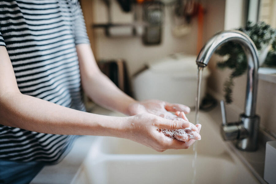 Cropped shot of a woman maintaining hands hygiene and washing hands with soap in the sink Photograph by D3sign