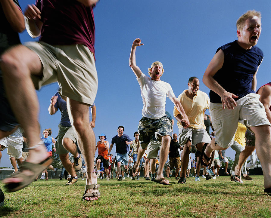 Crowd of men running, low angle Photograph by Mike Powell