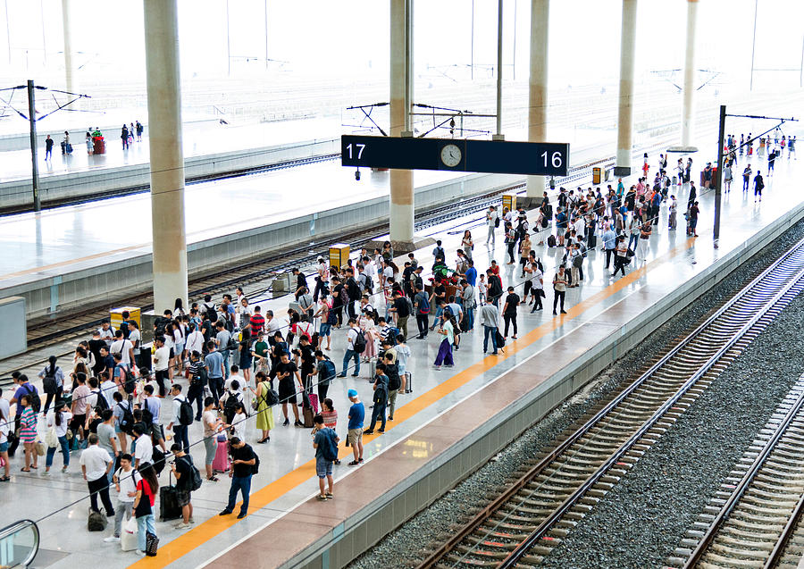 Crowd of passengers waiting on station platform Photograph by Baona