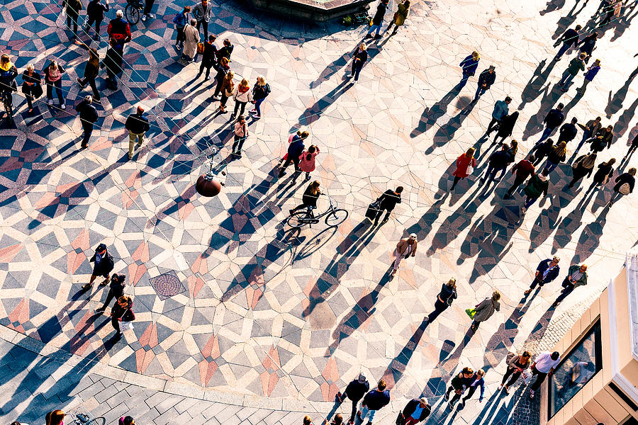 Crowd of people walking on a city square at sunset Photograph by Alexander Spatari