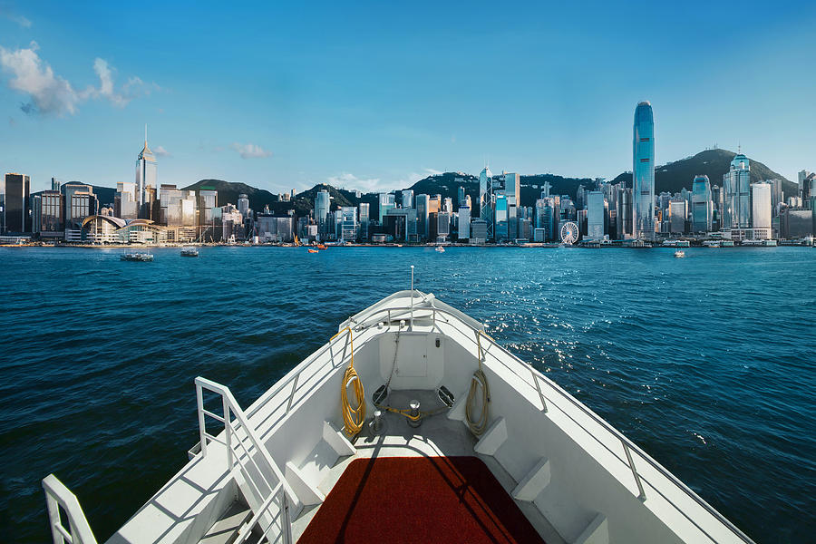 Cruise ship sailing across Victoria Harbour against the city skyline of Hong Kong on a sunny day Photograph by D3sign