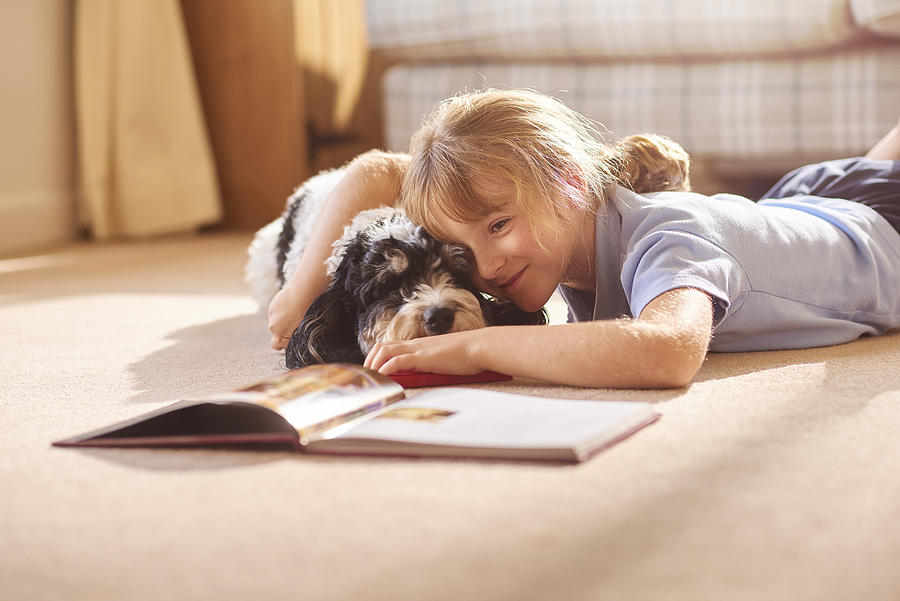 Cudding Her Dog Reading A Book Photograph by Sturti