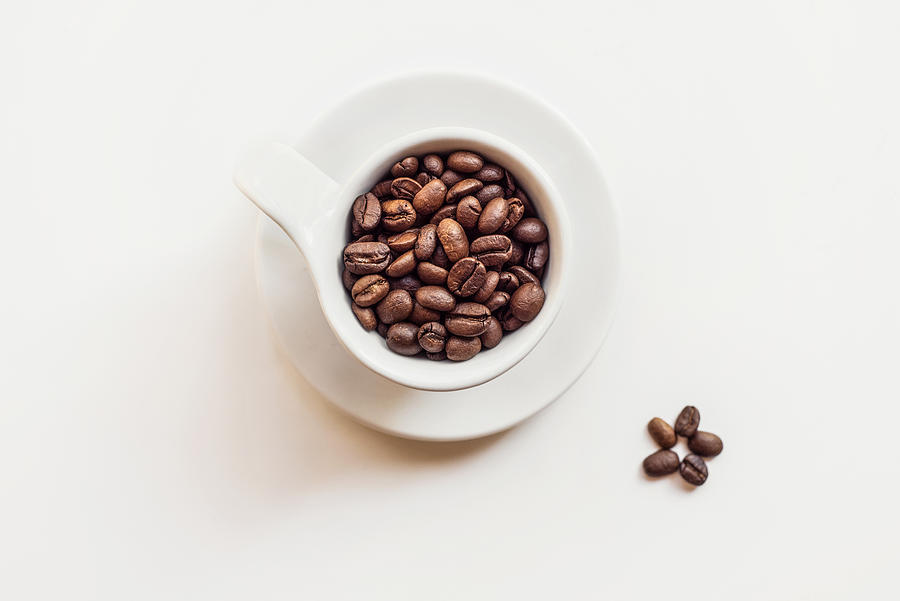 Cup of roasted coffee beans on white Photograph by Natalia Ganelin