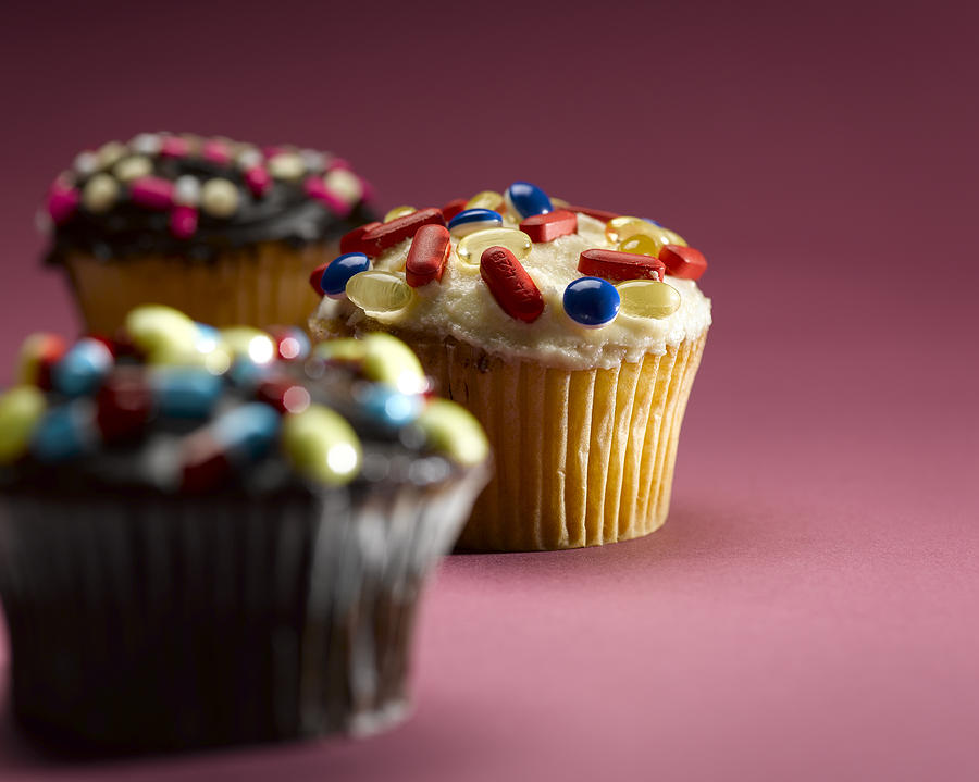 Cupcakes decorated with pills, close-up Photograph by Jeffrey Hamilton