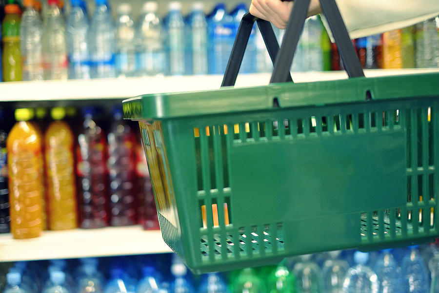 Customer holding shopping basket in the food store Photograph by Gremlin