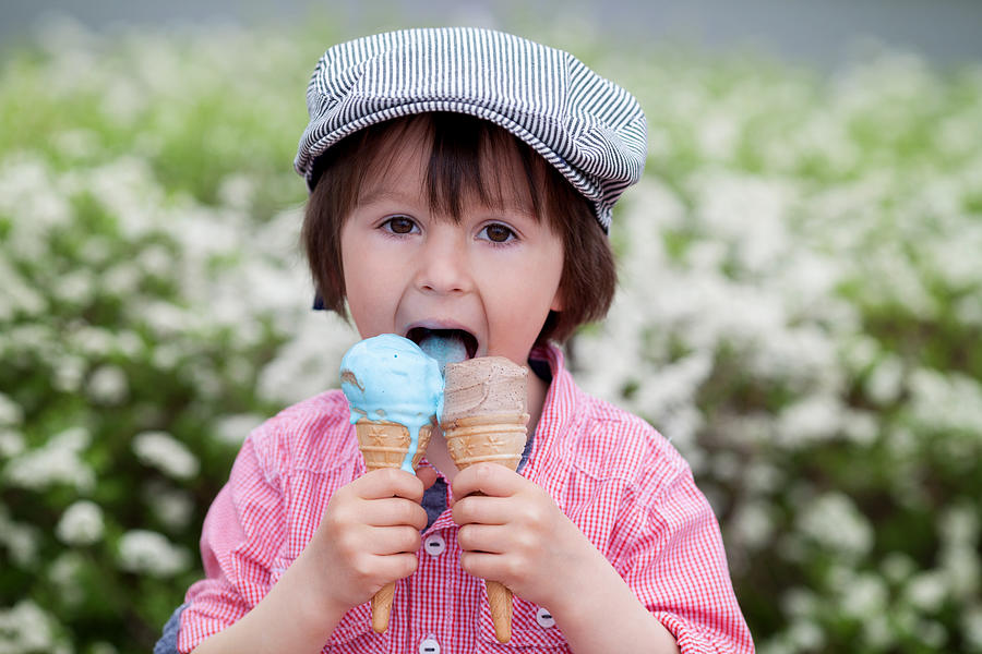 Cute boy, eating two ice creams in the park Photograph by Tatyana Tomsickova Photography
