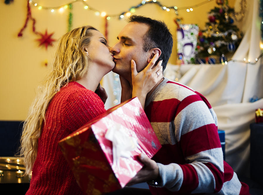 Cute couple with gift kissing of New Year eve. Photograph by Viktor Cvetkovic