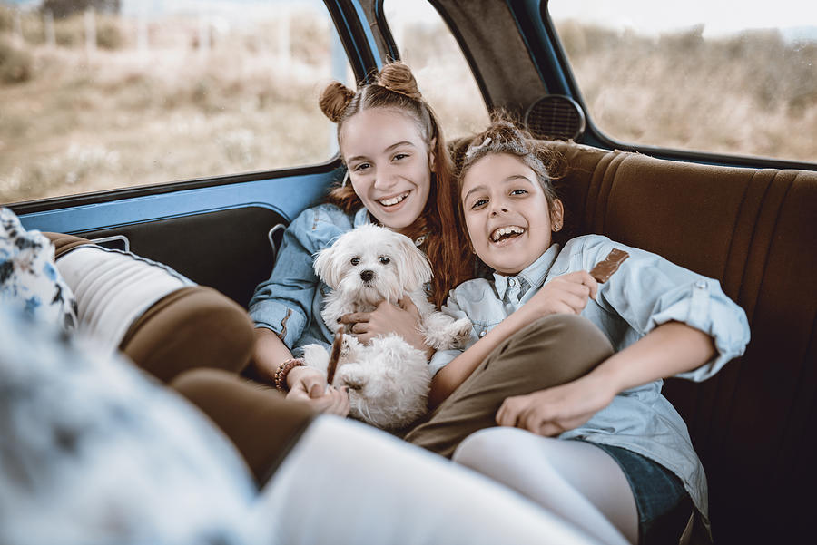 Cute Sisters Posing With Their Doggy In a Vintage Car Photograph by AleksandarGeorgiev