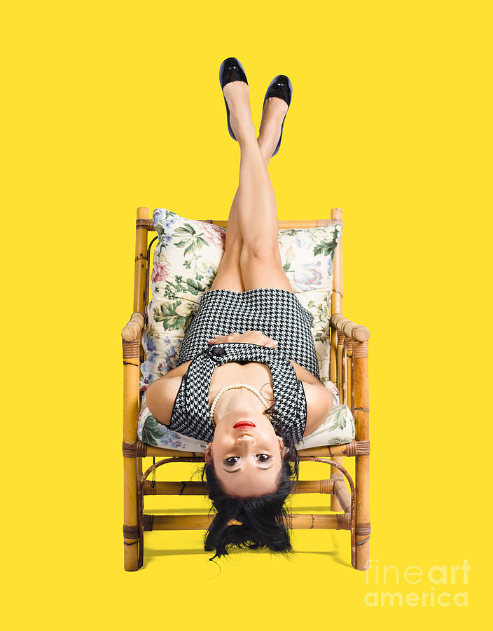 Cute young woman sitting upside down on chair Photograph by Jorgo Photography