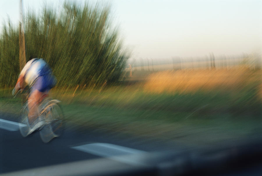Cyclist on road, rear view (blurred motion) Photograph by Sami Sarkis