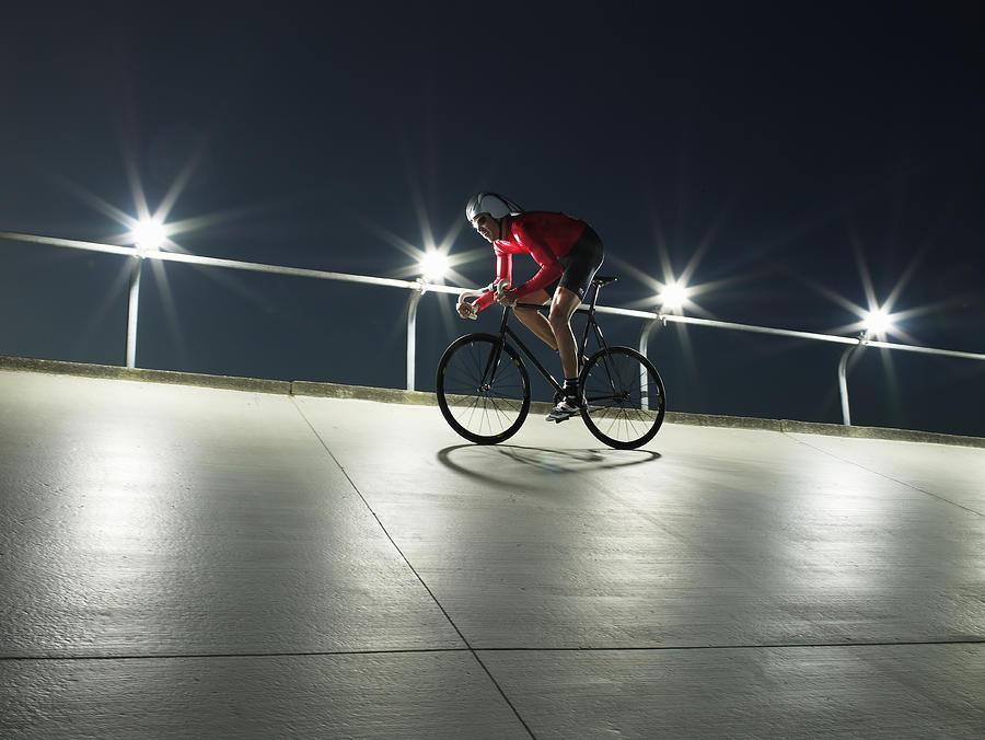 Cyclist on velodrome track, low angle view Photograph by Ryan McVay