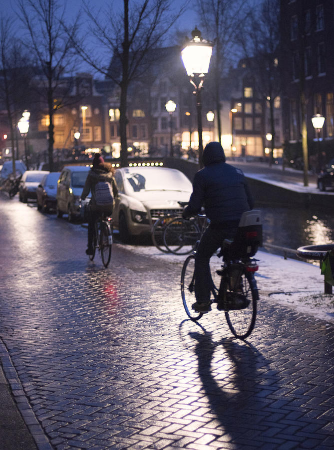Cyclists in Amsterdam at night Photograph by Lyn Holly Coorg
