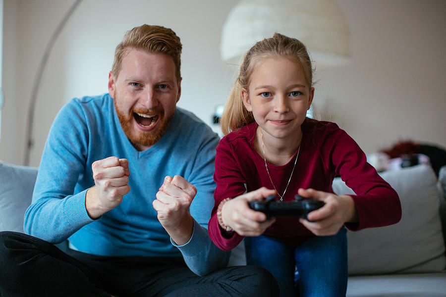 Dad and daugther playing video games Photograph by Milanvirijevic
