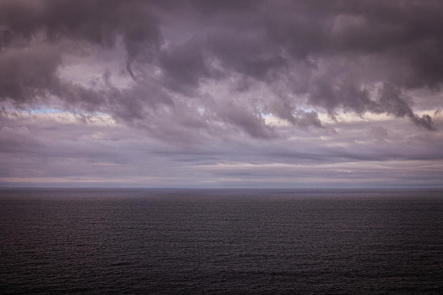 Dark clouds over a calm ocean Photograph by Jeff Swan - Pixels