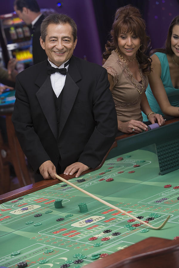Dealer at craps table and woman Photograph by Comstock Images
