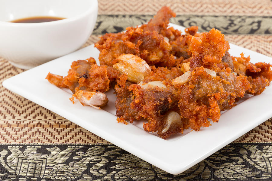 Deep fried pork tendons with black sauce Photograph by Warongdech