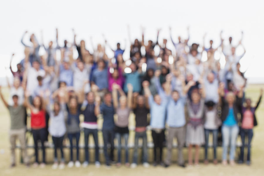 Defocused view of people with arms raised Photograph by Martin Barraud
