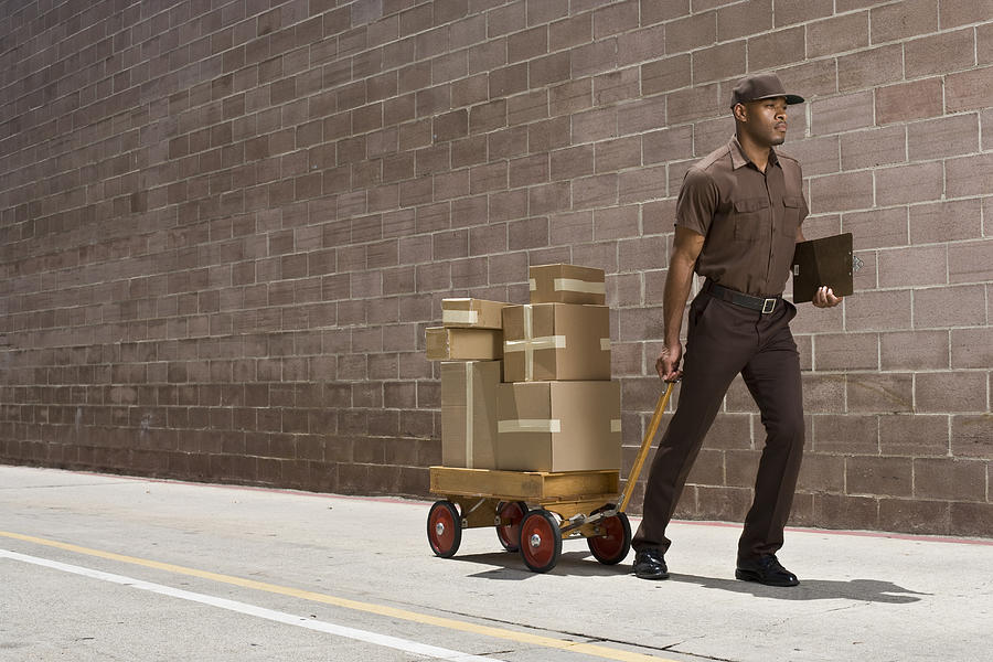 Delivery-person Carrying Boxes On Toy Wagon Photograph by Siri Stafford