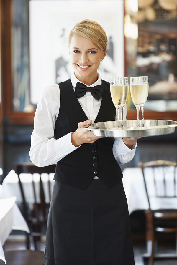 Denmark, Aarhus, Portrait of waitress holding champagne flutes on tray Photograph by Tetra Images - Yuri Arcurs